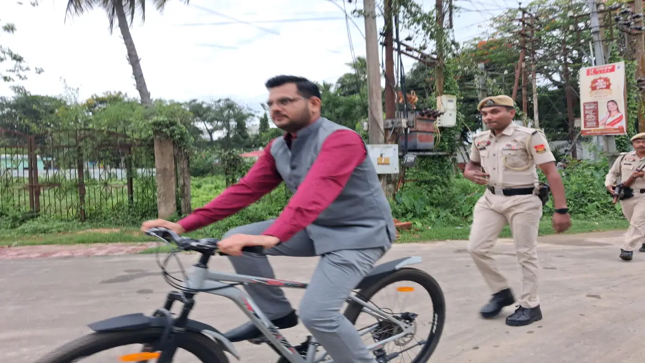 বাইসাইকেল চালিয়ে অফিসে গিয়েছেন জেলাশাসক। পেছনে দৌড়াচ্ছে নিরাপত্তারক্ষী । সমালোচনা সর্বত্র ।